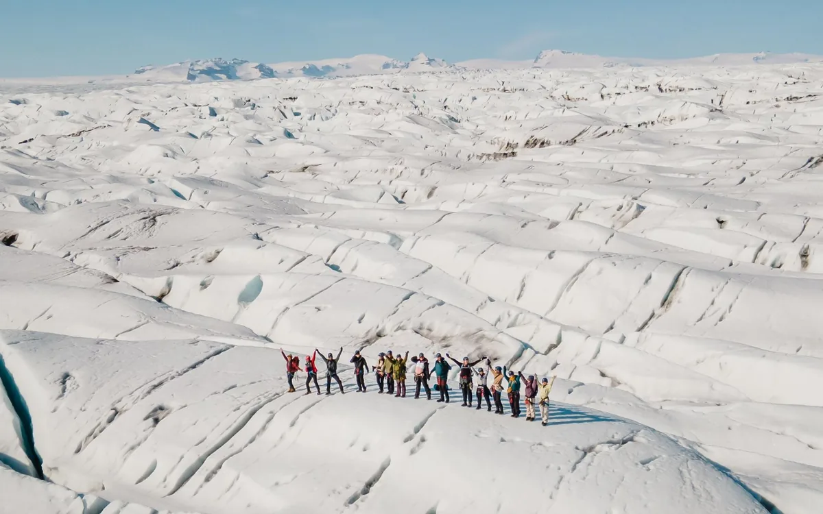 A line of hikers in crampons crossing a glacier in Iceland