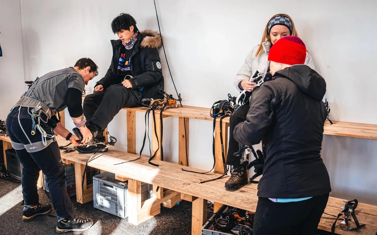 Crampons being fitted over walking boots before a glacier hike in Iceland