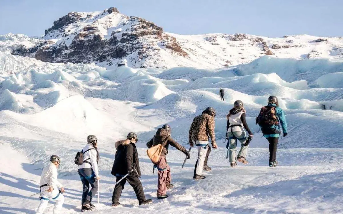 A small group standing on a glacier ridge in Skaftafell, Iceland