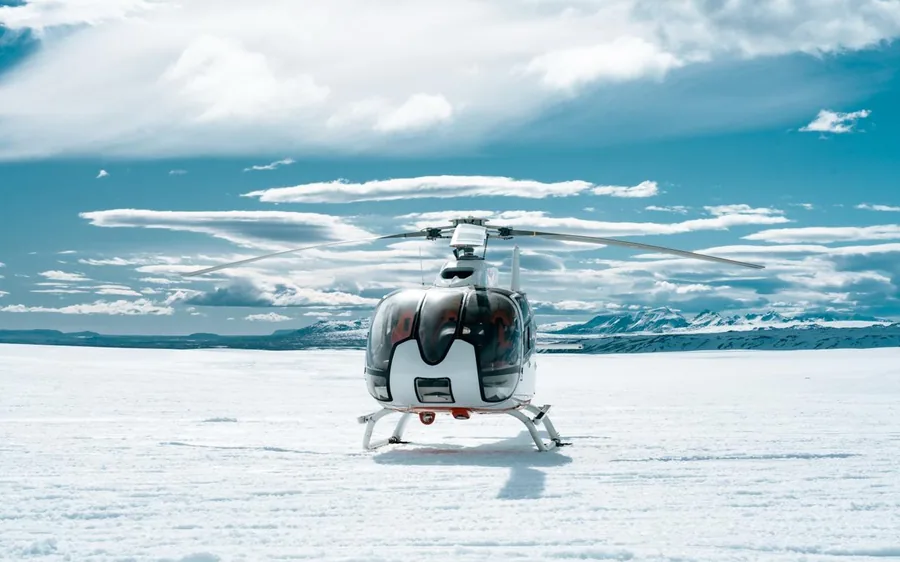A helicopter landed on the white surface of a glacier in Iceland
