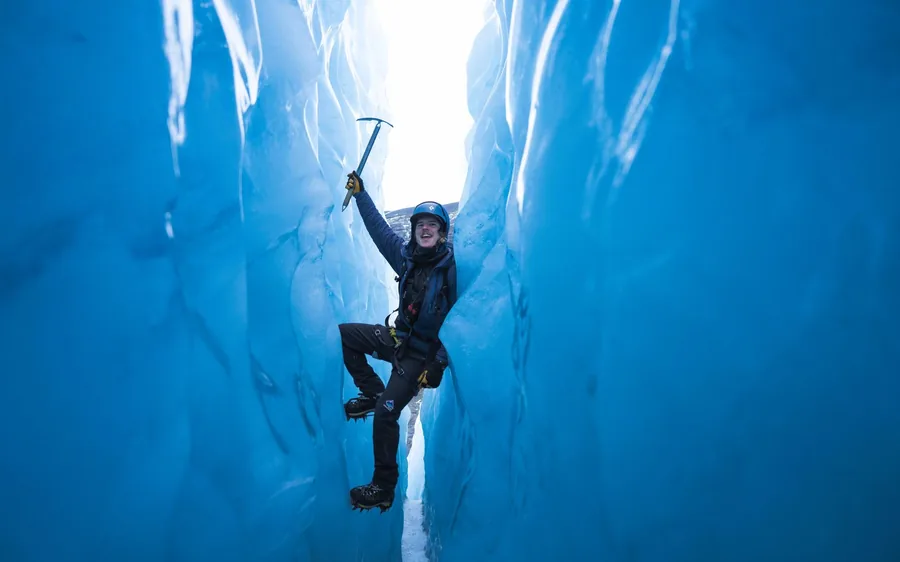 A climber on a blue ice wall on Solheimajokull glacier, Iceland